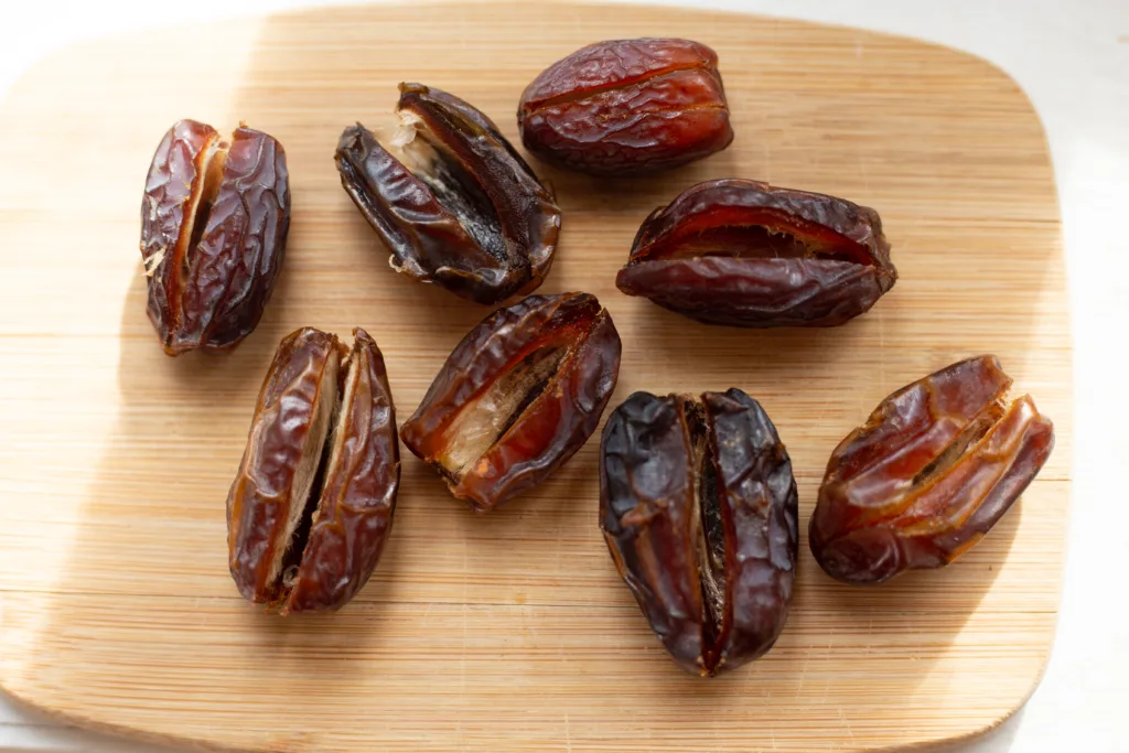 dates sitting on a wooden cutting board